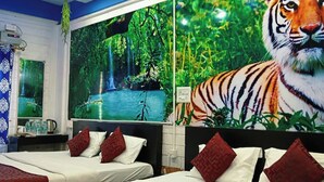 Ein Hotelzimmer mit zwei Betten, einem großen Tiger-Wandgemälde und einer Darstellung eines Wasserfalls an der Wand.