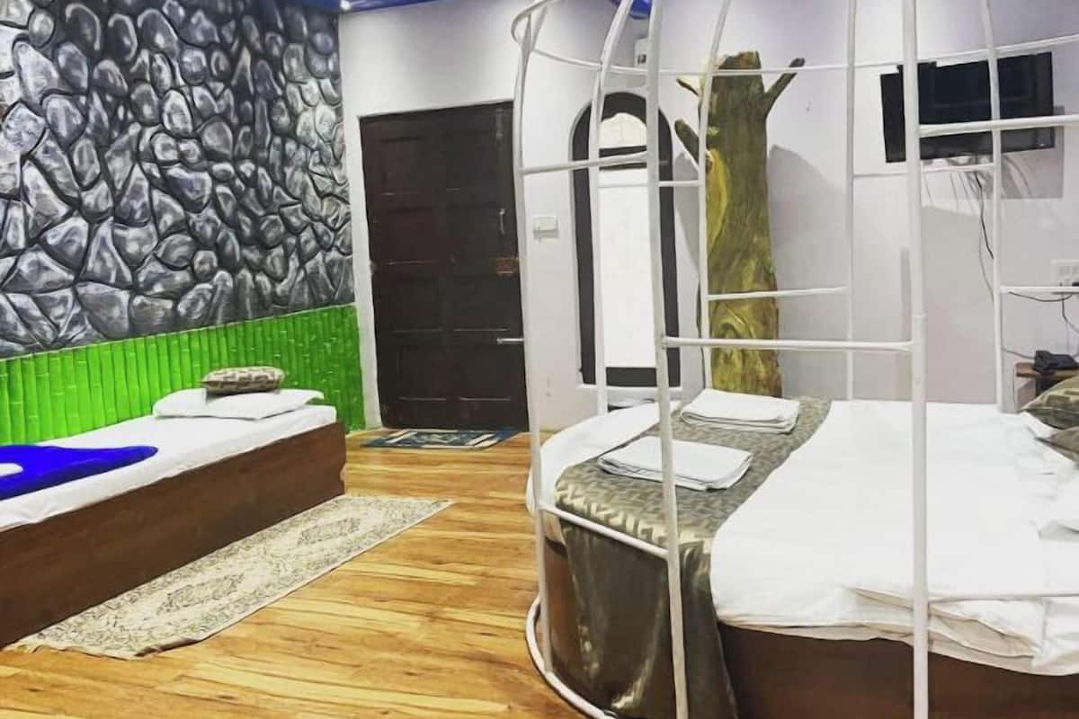 Une chambre dotée d’un lit au design incurvé original, d’un mur imitant la pierre et d’un plafond bleu.