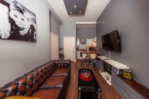 Relax in this stylish living room with a leather sofa, flat-screen TV, and dining area.