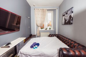 Relax in comfort with a flat-screen TV, comfortable bed, and a cozy leather sofa.