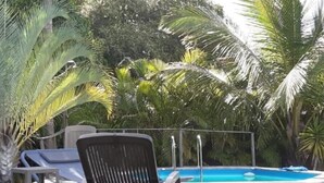 A poolside area with lounge chairs and a pool. - La Casa Colibris (Anse-Bertrand)