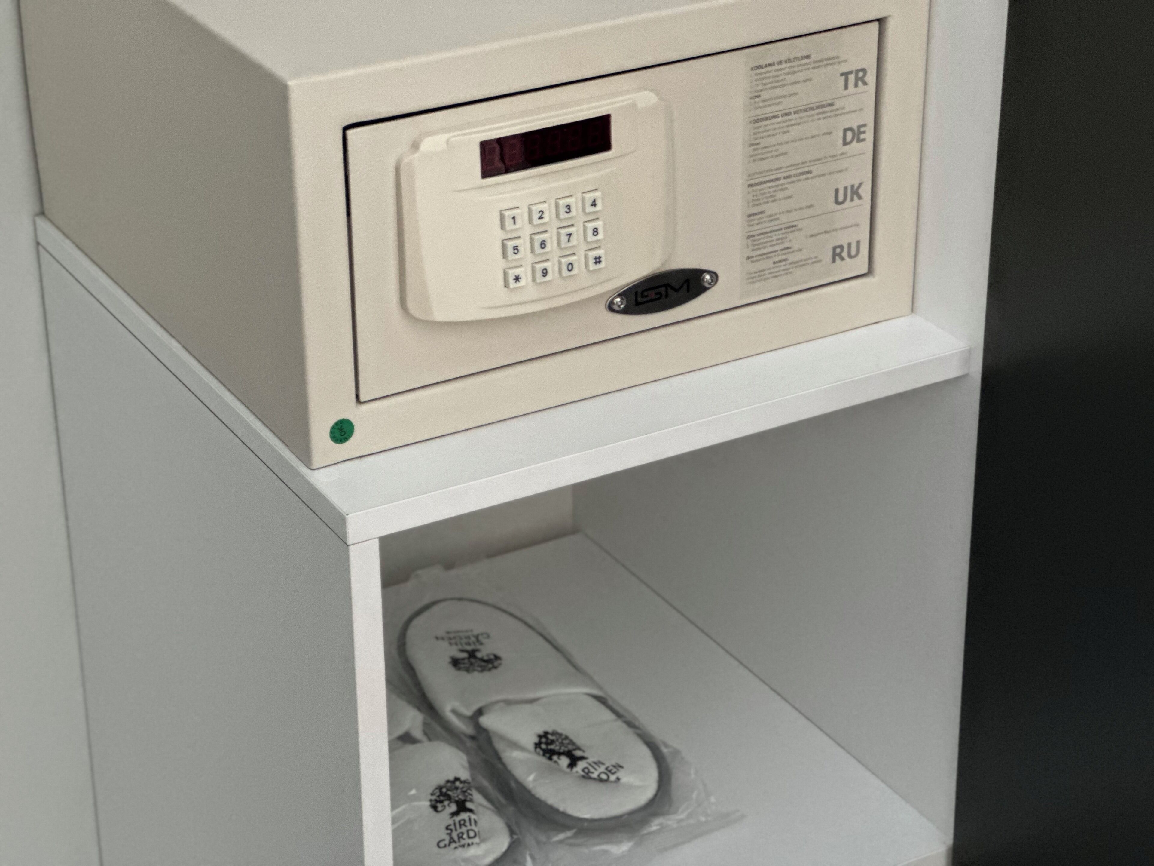 A white shoe locker with a keypad and a list of country codes.