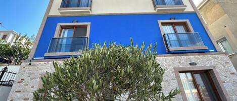 A two-story building with a blue facade and a stone base.