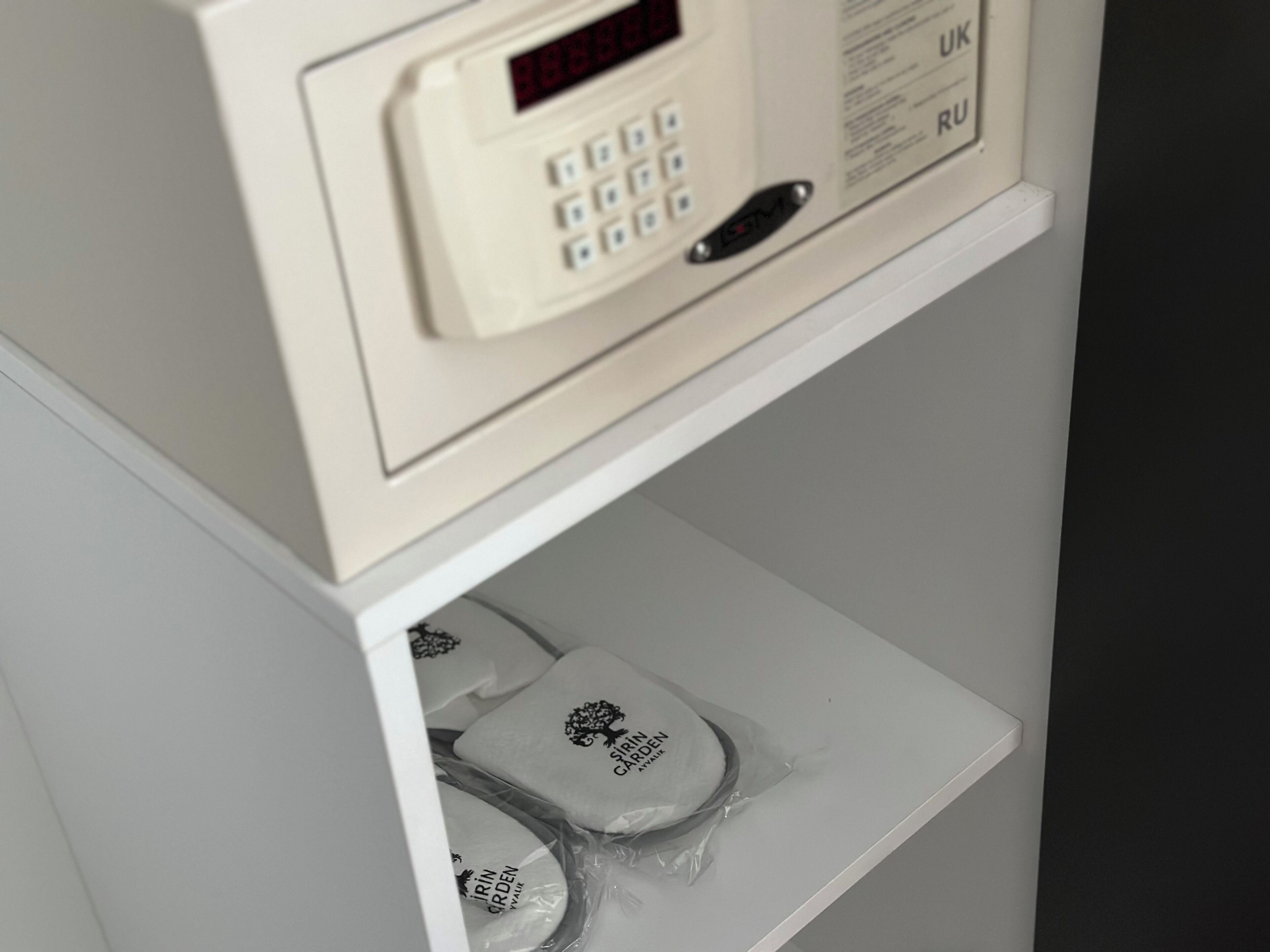 A control panel with a digital display and a keypad, and a shelf below with packaged items.
