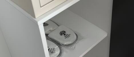 A control panel with a digital display and a keypad, and a shelf below with packaged items.