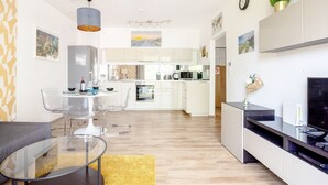 Ein modernes Apartment mit Essbereich, Küche und Wohnzimmer.