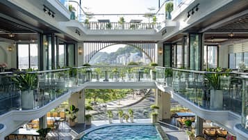 Experience the city from multiple levels in our spacious atrium, featuring a central pool surrounded by seating and lush greenery.