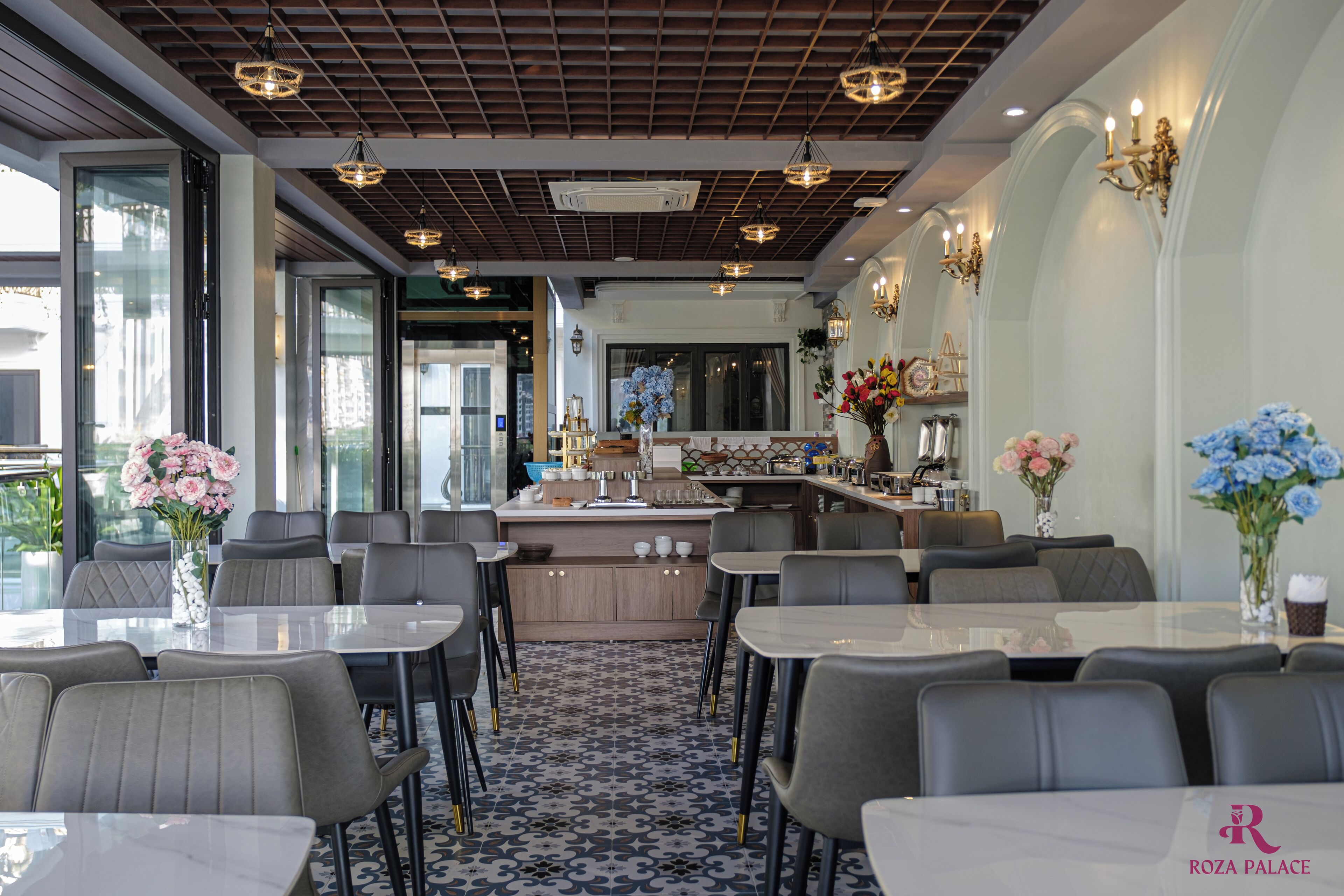 Un restaurante moderno con una isla central, varias zonas de estar e iluminación decorativa.