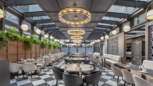 A modern restaurant with checkered flooring, round tables, and chairs. - Wish More Hotel Şişli (Istanbul)