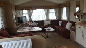 Ett mysigt vardagsrum med en soffa, ett litet bord, en tv och ett element.