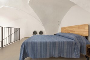 A bedroom with a bed, two chairs, a wooden headboard, and a staircase. - 3601 La Corte di Alice by Barbarhouse (Casarano)