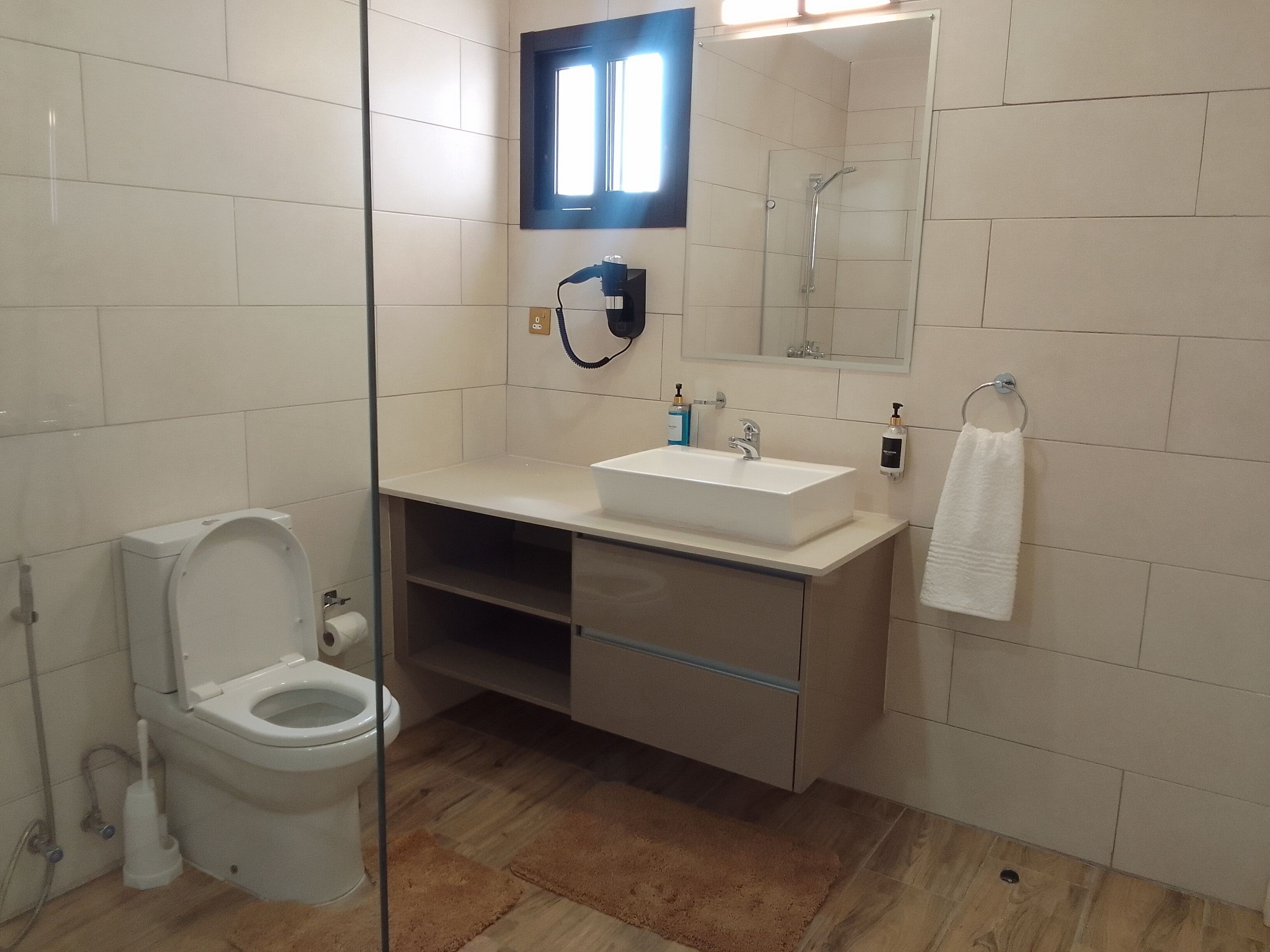 Ein modernes Badezimmer mit Toilette, Waschbecken und Dusche.