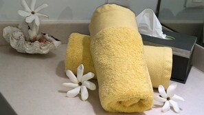 A neatly arranged set of towels and a tissue box on a countertop.