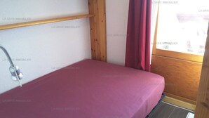 A small, enclosed space with a bed, a shower, and wooden walls. - Paradiski ski in ski out vallandry (LANDRY)