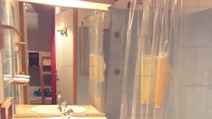 A bathroom with a sink, mirror, and shower curtain. - Paradiski ski in ski out vallandry (LANDRY)