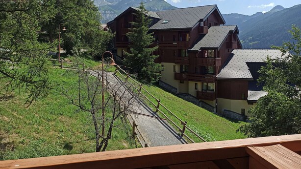 A multi-story wooden building with balconies, surrounded by trees and mountains. - Paradiski closed to the slopes vallandry (LANDRY)