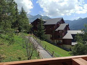 A multi-story wooden building with balconies, surrounded by trees and mountains. - Paradiski closed to the slopes vallandry (LANDRY)