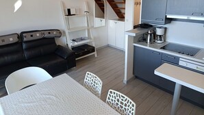 A compact living space with a kitchenette, a dining area, and a seating area with a sofa and chairs. - Paradiski closed to the slopes vallandry (LANDRY)