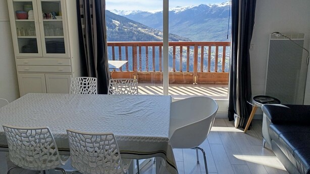 A room with a balcony, a dining table with chairs, a sofa, and a cabinet with glass doors. - Paradiski closed to the slopes vallandry (LANDRY)