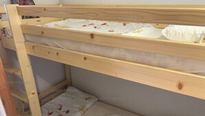 Un lit superposé à deux niveaux, chaque niveau étant équipé d’un oreiller et d’une couverture à motifs floraux.