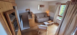 A cozy living room with a sofa, a wooden cabinet, a small table, and a window with curtains. - Paradiski closed to the slopes plan peisey (PEISEY-NANCROIX)