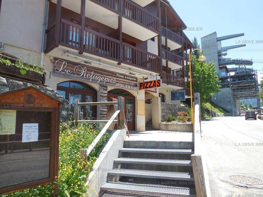 A building with a sign for 'Le Refuge Pizza' and a staircase leading to the entrance.