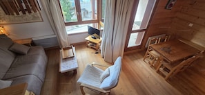 A cozy room with a sofa, a small table with a chair, a TV on a stand, and a window with curtains. - Paradiski closed to the slopes plan peisey (PEISEY-NANCROIX)