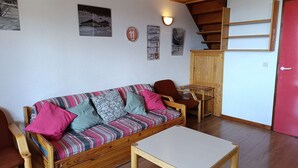 A cozy room with a wooden sofa, a small table, and a red door. - Paridiski closed to the slopes vallandry (LANDRY)