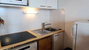 A compact kitchenette with a microwave, a built-in oven, a sink, and a dishwasher. - Paridiski closed to the slopes vallandry (LANDRY)