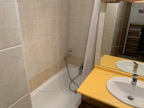 A bathroom with a bathtub, a shower, and a yellow sink with a mirror. - Paradiski closed to the slopes plan peisey (PEISEY-NANCROIX)