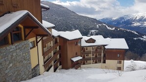 A wooden building with balconies and a stone facade, surrounded by snow-covered mountains. - Paradiski closed to the slopes plan peisey (PEISEY-NANCROIX)