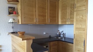 A kitchen with wooden cabinets, a black countertop, and a sink.