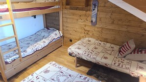 Een studentenkamer met stapelbedden, een klein schapje en een snowboard decoratie.