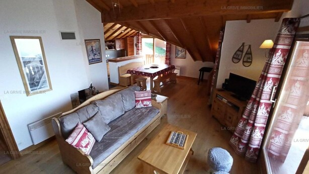 Een gezellige woonkamer met een bank, een bijzettafeltje en een klein vloerkleed.
