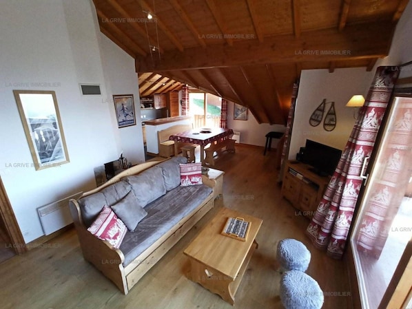 Een gezellige woonkamer met een bank, een bijzettafeltje en een klein vloerkleed.