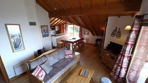 A cozy living room with a wooden sofa, a small wooden table, and a dog. - Paradiski renovated apartment vallandry (LANDRY)