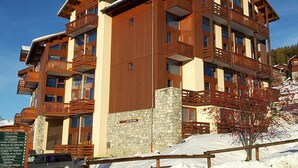 A multi-story hotel with wooden balconies and stone accents. - Paradiski closed to the slopes vallandry (LANDRY)