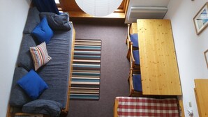 A compact living space with a sofa, striped rug, wooden table, and checkered bench. - Paradiski closed to the slopes vallandry (LANDRY)