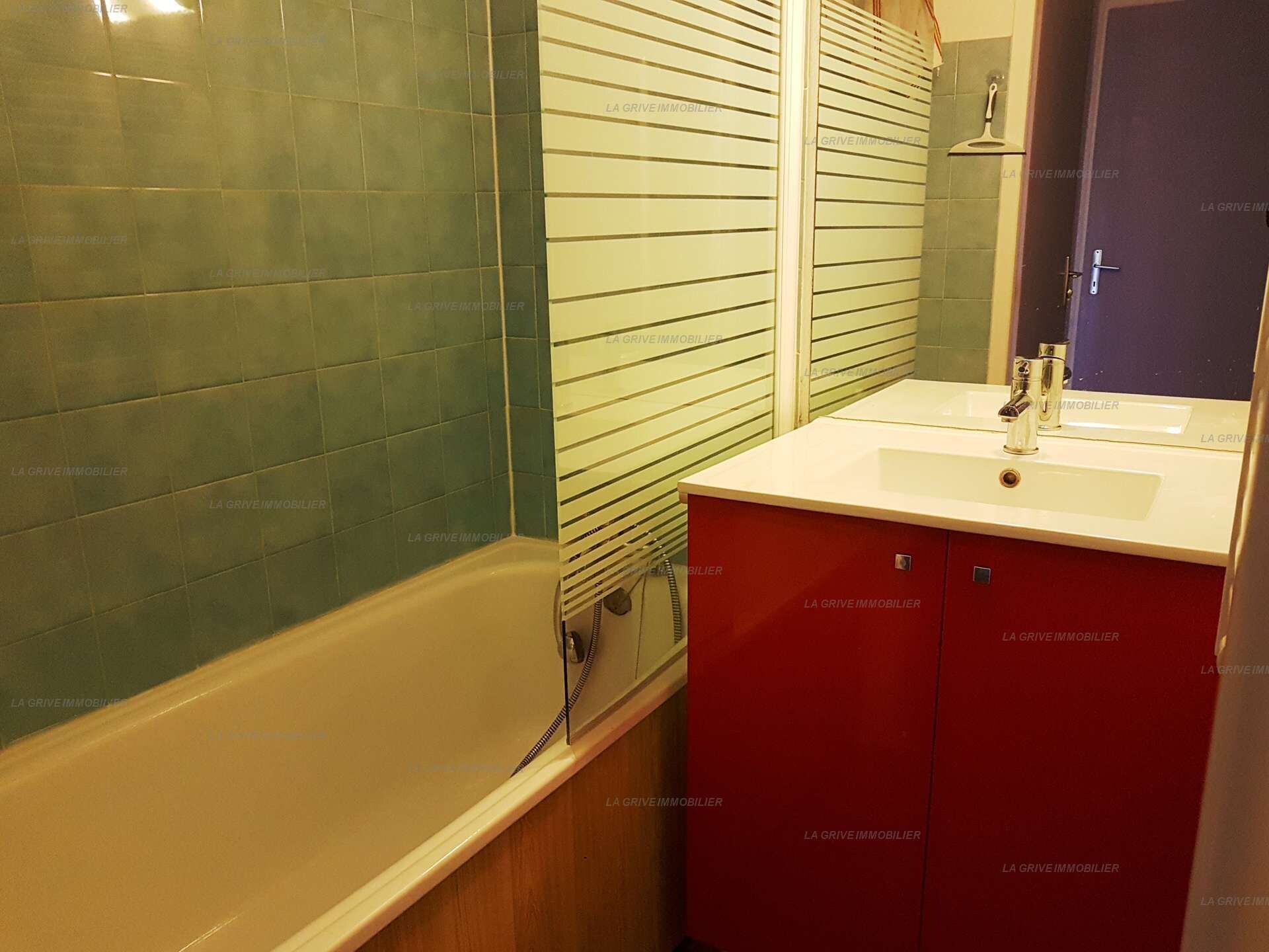 A bathroom with a bathtub, a sink, and a mirror.