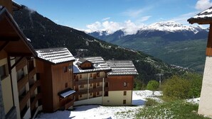 A wooden chalet with a balcony, set against a mountainous backdrop. - Apartment closed to the slopes in plan peisey (PEISEY-NANCROIX)