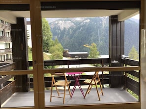 Un balcon avec vue sur la montagne, une table et des chaises.