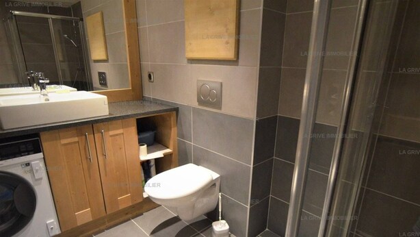 Une salle de bain moderne équipée d’un lavabo, de toilettes et d’une douche.