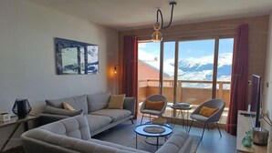 A living room with a sofa, chairs, a coffee table, and a painting on the wall.