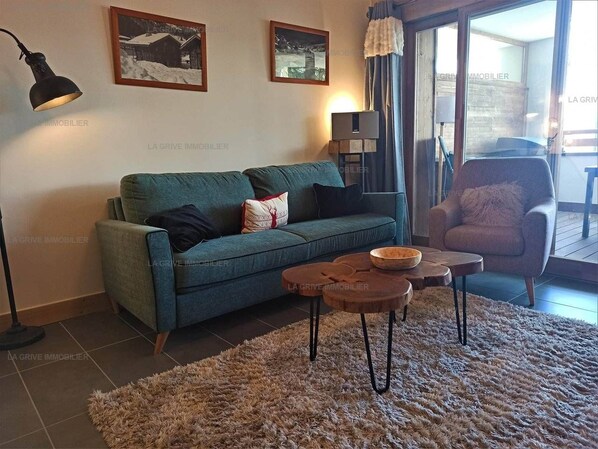 A living room with a sofa, a coffee table, a rug, and a chair.