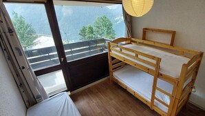 Ein Schlafzimmer mit Etagenbetten und Blick auf Berge durch ein Fenster.