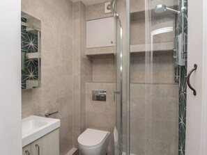 A modern bathroom with a glass shower enclosure, a toilet, and a sink. - Starfish (Penzance)