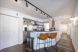 A modern kitchen with a central island, bar stools, and pendant lighting. - Luxury at its Finest - 3306 Towers - Traffic Free Beach - 3/3 Oceanfront (Ponce Inlet)