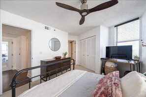A bedroom with a bed, a desk, a television, and a ceiling fan. - Luxury at its Finest - 3306 Towers - Traffic Free Beach - 3/3 Oceanfront (Ponce Inlet)