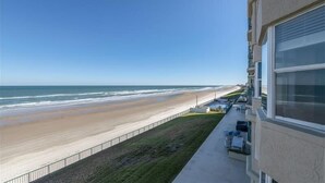 Een hotel aan het strand met een balkon met uitzicht op de oceaan.