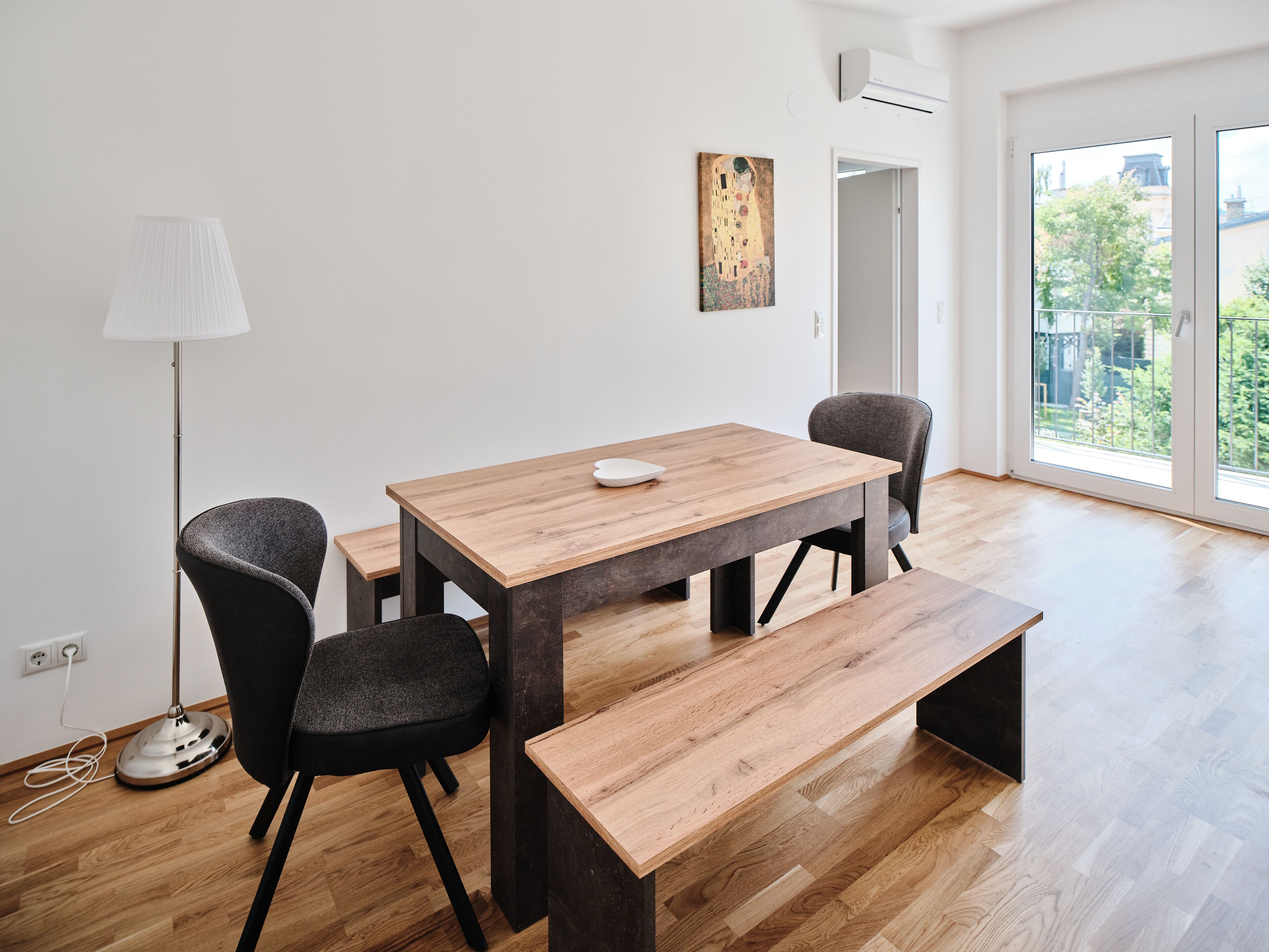 Un comedor moderno con una mesa de madera, sillas negras y un banco.